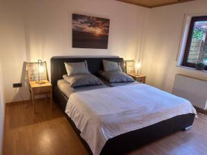 a bedroom with a large bed with two lamps on it at Ferienwohnung Elly 3 km zum Diemelradweg in Liebenau