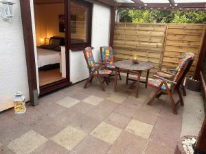a patio with a table and chairs and a bedroom at Ferienwohnung Elly 3 km zum Diemelradweg in Liebenau