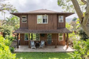 a house with a porch with a table and chairs at The Kumu House in Kailua-Kona