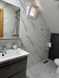 La salle de bains est pourvue d'un lavabo, d'un miroir et de toilettes. dans l'établissement Spacieuse villa familiale avec piscine Founty, à Agadir