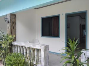 Casa blanca con balcón y TV. en ELEN INN - Malapascua Island Air-conditioned Room1, en Isla de Malapascua