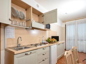 una cucina con armadi bianchi e lavandino di Apartment in Peschiera del Garda 22085 a Peschiera del Garda