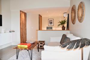 Franca St Jean في Saint-Jean: غرفة معيشة مع أريكة بيضاء وطاولة