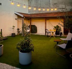 een patio met groen gras en een tafel en stoelen bij MAISON LE BEAULIEU in Vichy