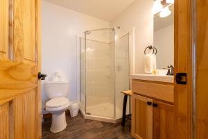 uma casa de banho com um WC e uma cabina de duche em vidro. em Keweenaw Waters Resort em Houghton
