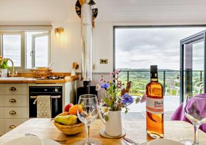 a kitchen with a table with a bottle of wine and glasses at Cwt Eithin in Llangadfan