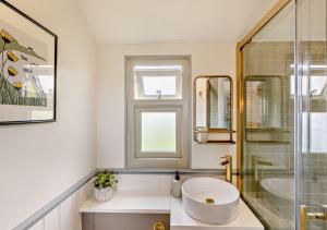 a bathroom with a sink and a glass shower at Cwt Eithin in Llangadfan