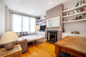 a living room with a couch and a fireplace at Amazing 2BDR apt near park, Herne Hill in London