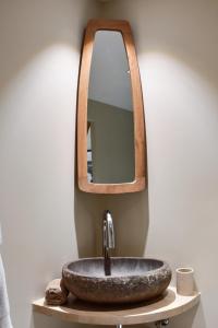 y baño con lavabo de piedra y espejo. en Franca St Jean, en Saint-Jean