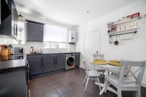 a kitchen with a table and chairs and a sink at Amazing 2BDR apt near park, Herne Hill in London