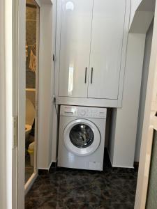 a washer and dryer in a bathroom with a cabinet at SJ Apartment in Tulcea