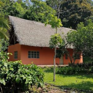 uma pequena casa laranja com um telhado de palha em Casa Capirona 1 - Laguna Azul em Tarapoto
