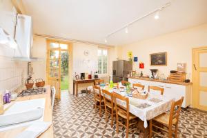 cocina y comedor con mesa y sillas en Château pour se retrouver, en Larochemillay