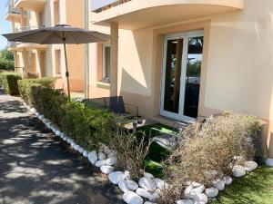 a house with an umbrella and some rocks at Appartement Les Hauts du Beaujolais in Limas