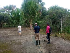 un grupo de personas de pie en un campo de tierra con palmeras en Ayatur Lodge Iquitos, en Iquitos