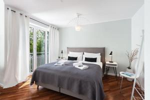 a white bedroom with a large bed and a window at Blueberry Living - Design Loft nahe München - Dachterrasse - S-Bahn in Gauting
