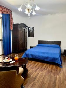Un dormitorio con una cama azul y una mesa en Lo Scrigno B&B, en Montemiletto