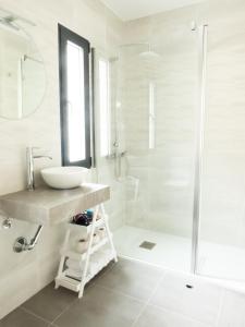 y baño blanco con lavabo y ducha. en VUT Adarve, en Ávila