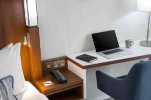 a room with a desk with a laptop computer on it at Courtyard by Marriott Inverness Airport in Inverness