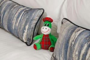 a stuffed toy sitting on a bed next to two pillows at Courtyard by Marriott Inverness Airport in Inverness