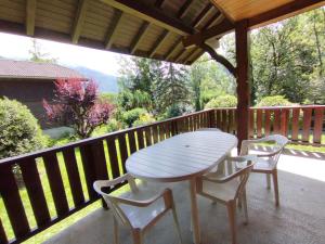 a white table and chairs on a porch with a view at Tifanlo in Samoëns