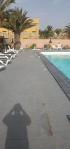 a shadow of a person standing next to a swimming pool at Villa Costa Antigua A3 in Costa de Antigua