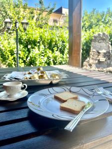 a table with a plate of sandwiches and a cup of coffee at Lo Scrigno B&B in Montemiletto