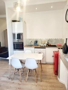 - une cuisine avec une table blanche et des chaises blanches dans l'établissement Grand appartement proche gare de Marseille hypercentre, à Marseille