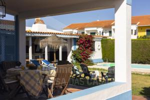 a patio with a table and chairs and a pool at Casa da Praia by AcasaDasCasas in Santo Isidoro