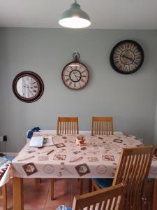 a table with four chairs and two clocks on the wall at 1 Cartrun Breac N39D7H6 Opposite Longford Rugby Club - See the Yellow Door in Longford