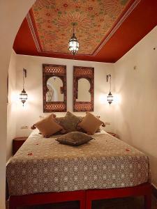 Schlafzimmer mit einem Bett mit zwei Spiegeln an der Decke in der Unterkunft Riad Le Coq Berbère in Marrakesch