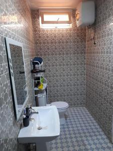 a bathroom with a sink and a toilet at Résidence imeris mbour 8 chambres in Dinnguiraye +21 photos