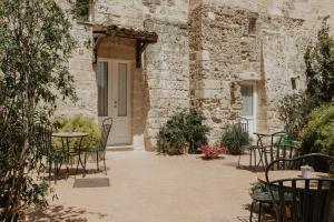 un patio con mesas y sillas frente a un edificio en Le Dodici Lune, en Matera