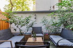 un patio con 2 sillas, una mesa y plantas en Garden Apartment, Close to Schönbrunn, en Viena