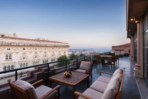 - un balcon avec des chaises et des tables dans un bâtiment dans l'établissement Park Hyatt Istanbul - Macka Palas, à Istanbul