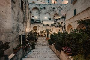 an alleyway in an old building with potted plants at Le Dodici Lune in Matera