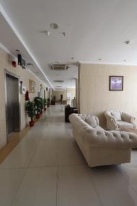 a lobby with two couches and a hallway with plants at Ayan ALMUEABADH -1700m to ALharam in Mecca