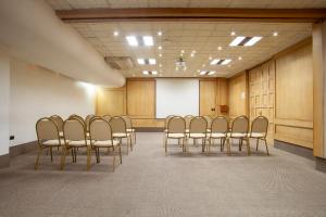 a conference room with a row of chairs and a whiteboard at HOTEL EL DORADO in Concepción