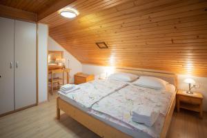 um quarto com uma cama e um tecto em madeira em Apartmaji Colja em Bohinj