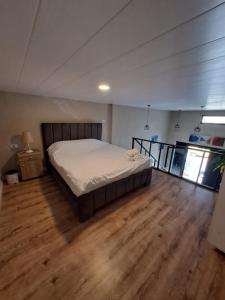 a bedroom with a bed and a wooden floor at Duplex guest house in Batroun in Batroûn