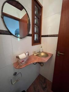 uma casa de banho com um lavatório e um espelho em Casa vista lago Vitória Régia em Holambra