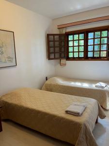 Duas camas num quarto com uma janela em Casa vista lago Vitória Régia em Holambra