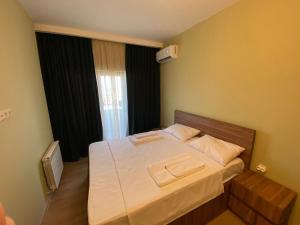 a bedroom with a bed with two towels on it at Dani Apartment in Kutaisi