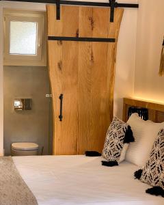 um quarto com uma cama e uma porta de madeira em Casa Nina em Patitiri