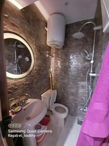 y baño con lavabo, aseo y espejo. en Hayat Pyramids House 237T, en ‘Ezbet `Abd el-Ḥamîd