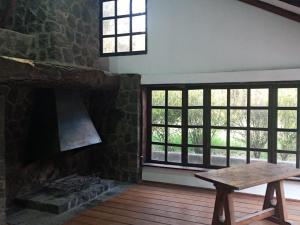 Quinta los Eucaliptos في كيتو: غرفة بها موقد حجري وطاولة خشبية