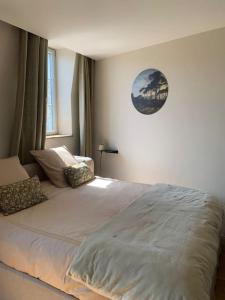 a bedroom with a large white bed with pillows at Appartement très confortable le Renaissance entre Paris et CDG in Écouen