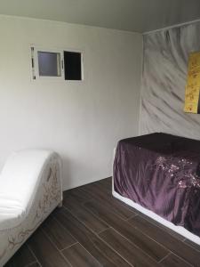 1 dormitorio pequeño con 1 cama y suelo de madera en Tantralove, en Aguatona