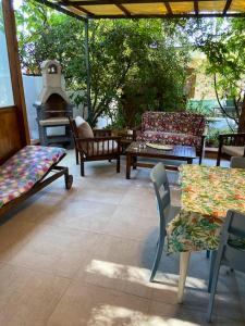 un patio con sillas, mesa y chimenea en 2 bedrooms bungalow at Marina di Camerota 60 m away from the beach with enclosed garden and wifi en Marina di Camerota