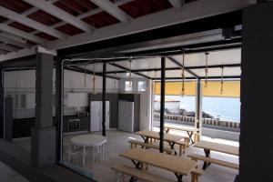 a kitchen and dining room with tables and benches at Las Eras Nest Hostel in Las Eras